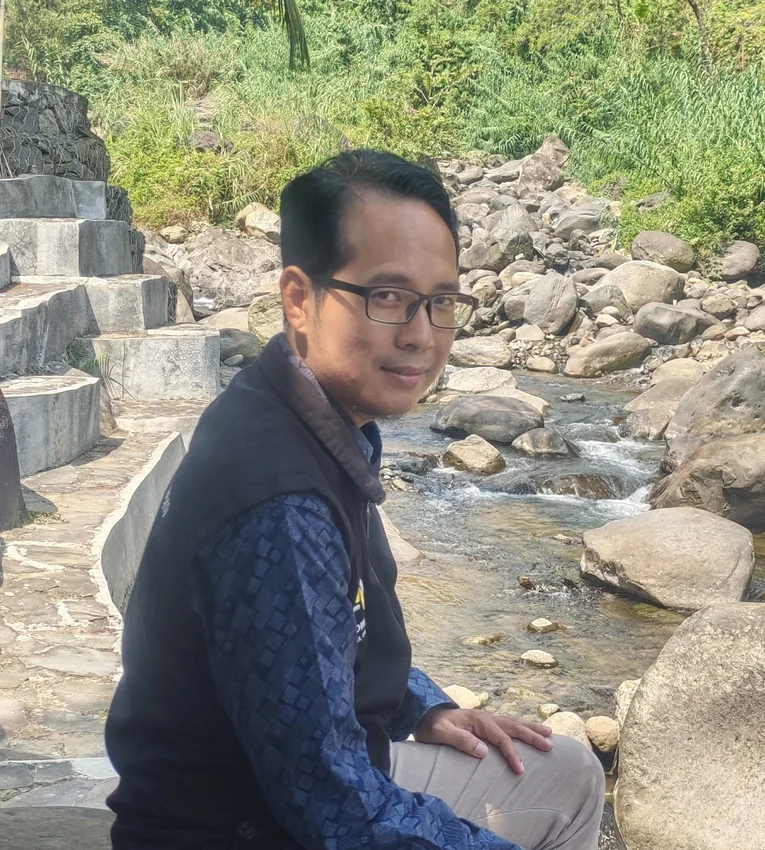 Defriansyah, penulis ebook Closing Sakti, duduk di tepi sungai